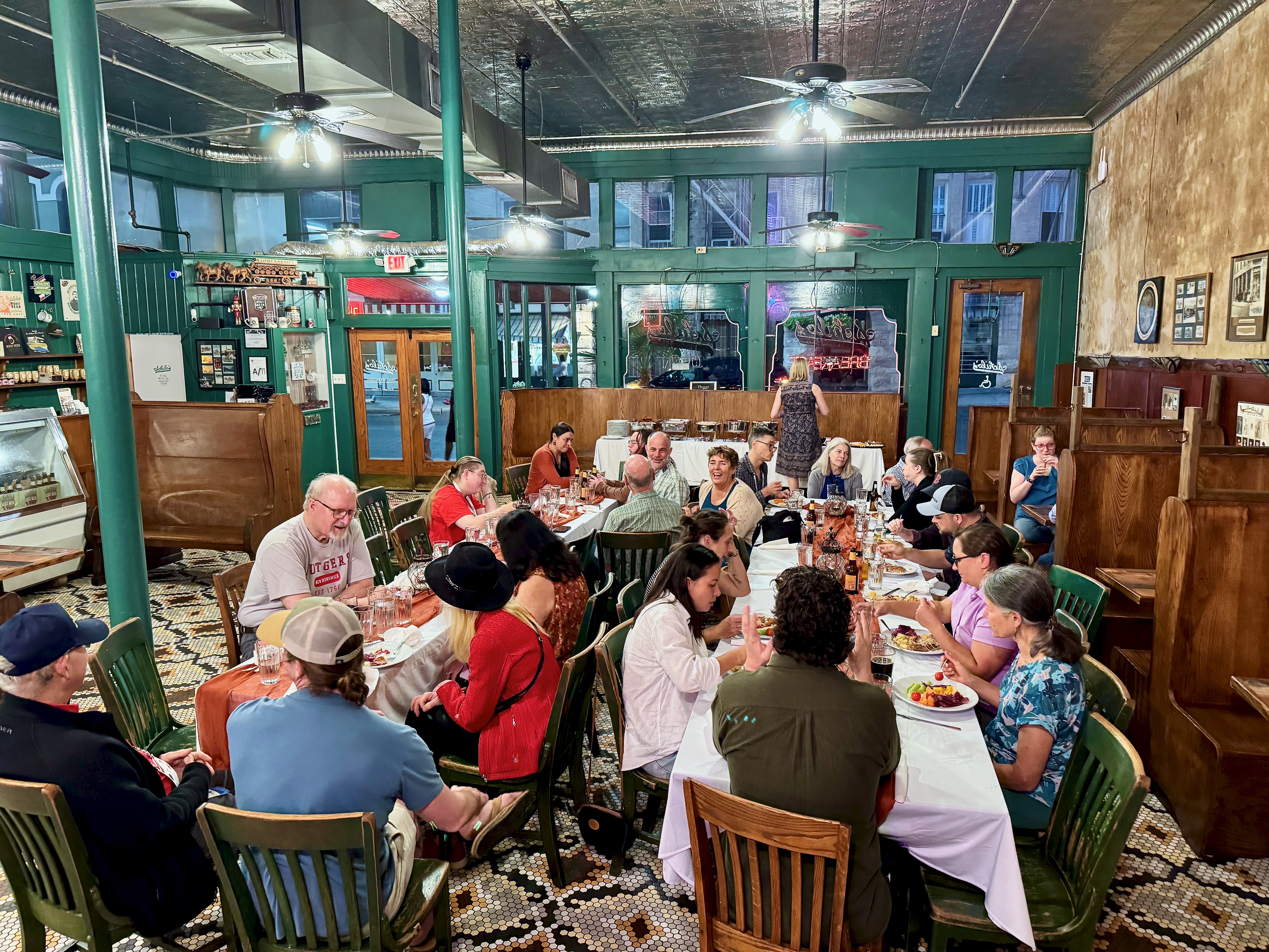 Group of EPS faculty, staff, and students sitting at tables at an event