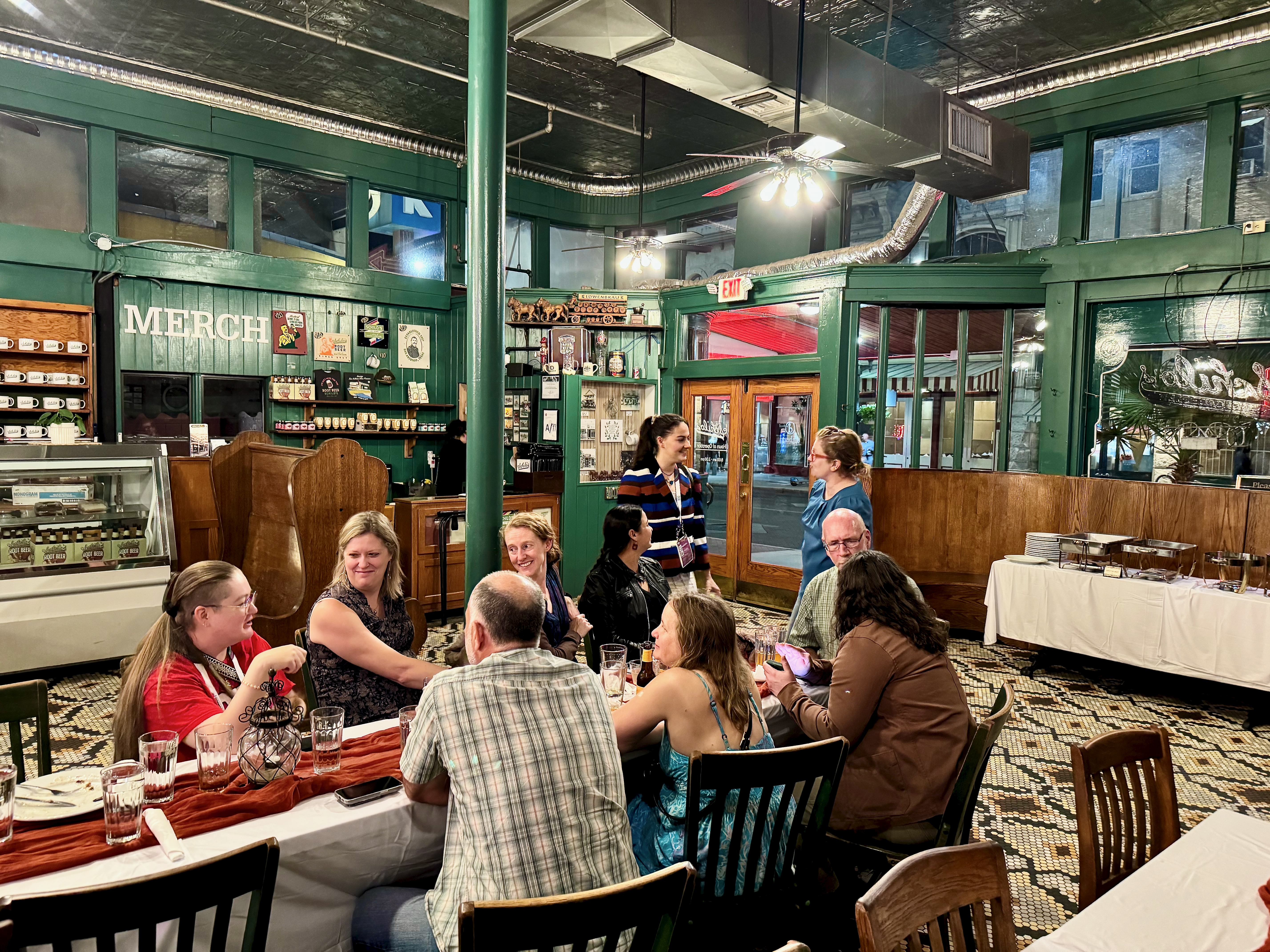 Group of EPS faculty, staff, and students sitting at tables at an event